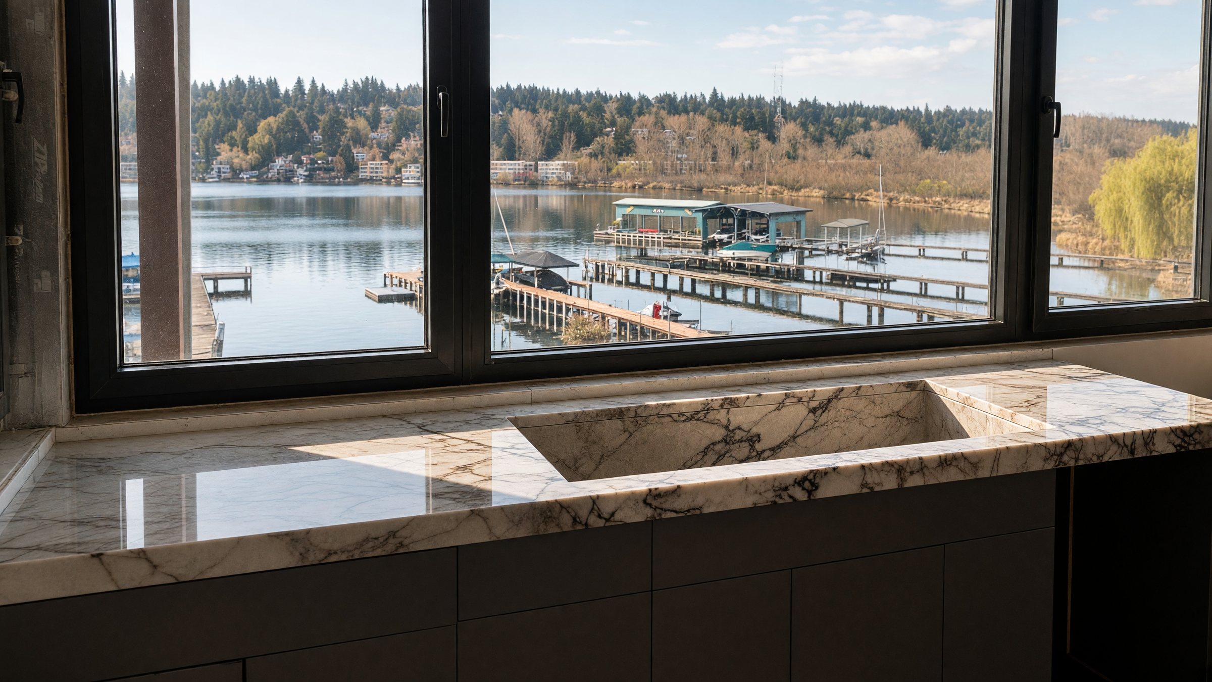 Marble countertop with integrated sink in front of a lake-view window